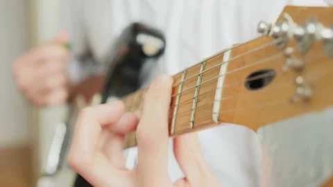 Close-up male hands clamp the strings on the fretboard of an electric guitar Stock-Footage 194834556