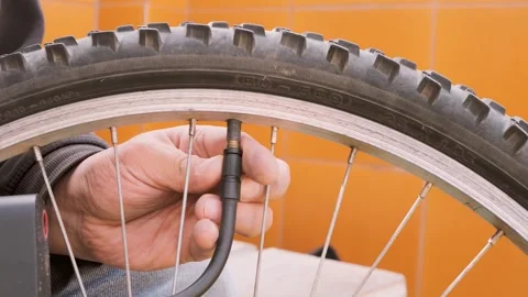 Close up male hands connecting pump to bicycle wheel for inflation Stock Footage 327203994