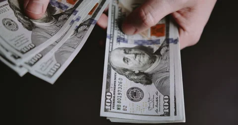 Close-up of male hands counting a stack of hundred-dollar US banknotes. Stock Footage 205041850