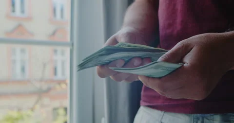 Close-up of male hands counting a stack of hundred-dollar US banknotes. Stock Footage 209584955