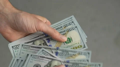 Close-up of male hands counting a stack of US hundred dollar bills. Stock Footage 229875361