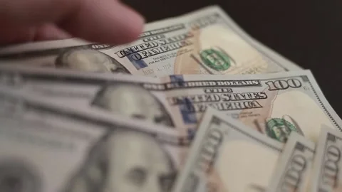 Close-up of male hands counting a stack of hundred-dollar US banknotes Stock Footage 237701595