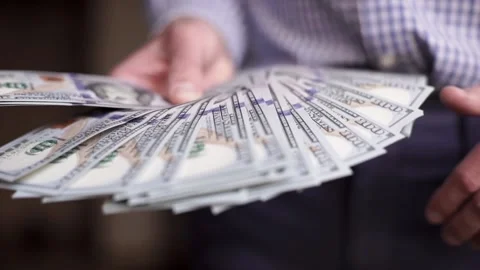 Close-up of male hands counting a stack of hundred-dollar US banknotes Stock Footage 238752026