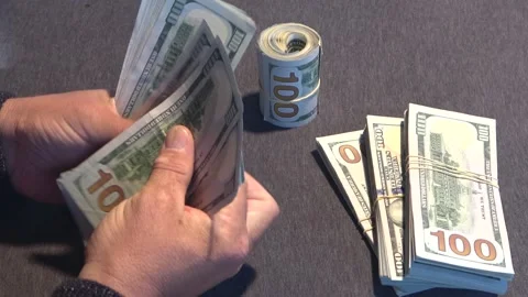 Close-up of male hands counting a stack of US hundred dollar bills Stock Footage 254408434