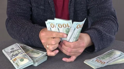 Close-up of male hands counting a stack of US hundred dollar bills Stock Footage 254415331