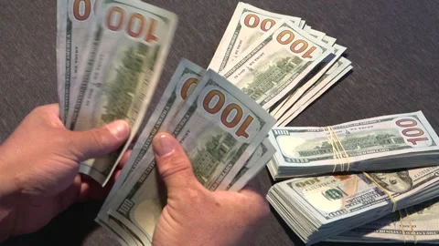 Close-up of male hands counting a stack of US hundred dollar bills. Stock Footage 254415341