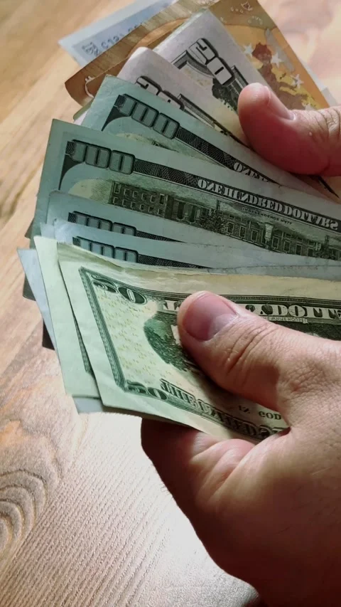Close-up of male hands counting a stack of hundred-dollar US banknotes. Stock Footage 264979743