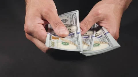 Close-up of male hands counting a stack of hundred-dollar US banknotes. a busine Stock Footage 276891944