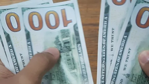 Close-up of male hands counting a stack of hundred-dollar US banknotes Stock Footage 289201293