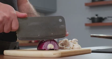 Close up of male hands cut fresh red onion on wooden cutting board in kitchen Stock Footage 254565062