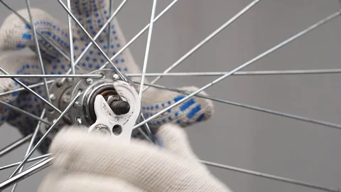 Close-up of male hands in gloves remove the front wheel of a bicycle from a fork Stock Footage 115125884