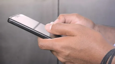 Close up of the male hands holding black smartphone device, scrolling the screen Stock Footage