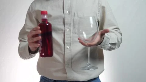 Close-up of male hands holding empty glass and bottle of red alcohol (wine) Stock Footage 310330130