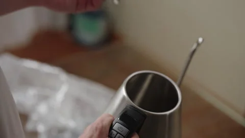 Close-up of male hands lifting lid of new stainless steel electric kettle Stock Footage 306589618
