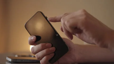 Close-up of male hands manipulating sim card for insertion into modern Stock Footage 321401256