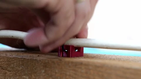 Close-up of male hands mounting a white electrical cable onto a wooden board Video stock 345090024