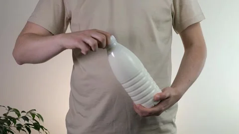 Close-up of male hands opening a plastic bottle of milk or other dairy product. Stock Footage 314091694