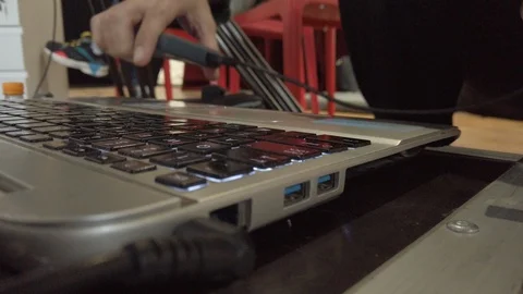 Close-up male hands pluging usb cable into connector on laptop indoor Stock Footage 121740033