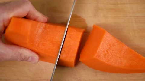 Close up male hands preparing pumpkin for cooking with knife on cutting board Vidéo 166926181