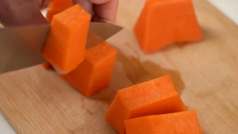 Close up male hands preparing pumpkin for cooking with knife on cutting board Stockbeeldmateriaal 166926241