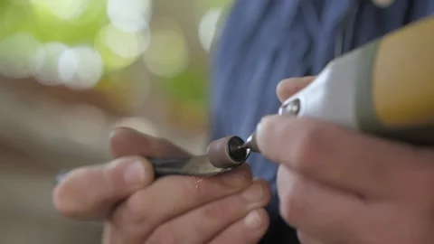 Close-up. male hands process a metal workpiece with a straight grinder. makin Stock Footage 140323315