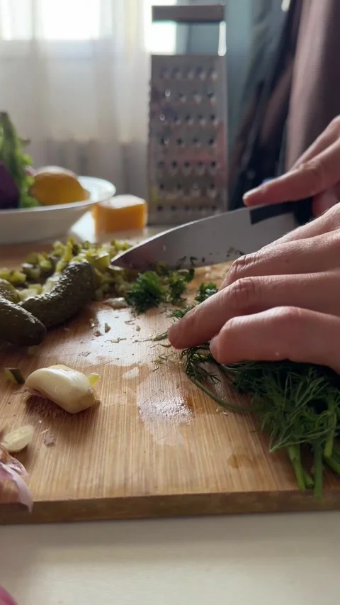 Close-up of male hands rapidly chopping pickles and herbs for salad dressing. Stock Footage 337359574