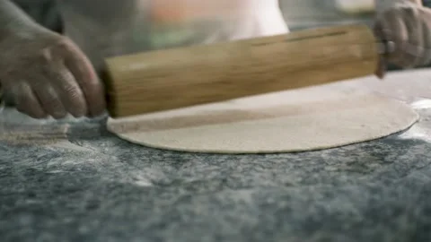 Close-up male hands roll out pastry with wooden rolling pin on a stone table Stock-Footage 199214474