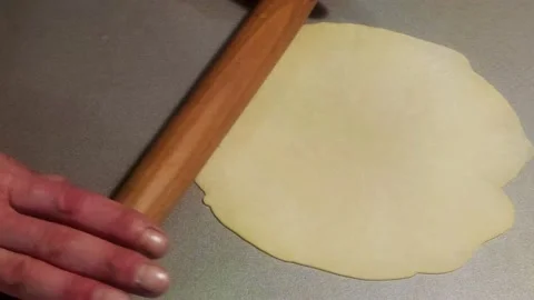 Close-up of Male Hands rolling out the Dough With a Rolling Pin on the Table. Stock Footage 239164548