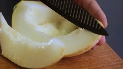 Close-up of male hands slicing delicious melon in the kitchen. Summer and Stock-Footage 153141663