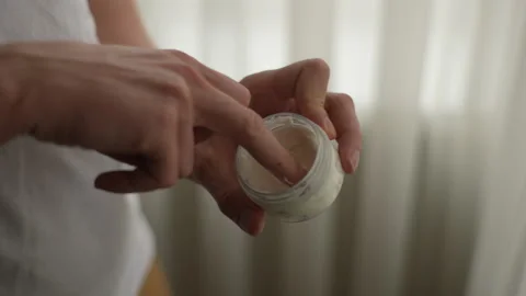 Close-up of male hands taking face cream from jar, preparing to apply Stock Footage 297627014