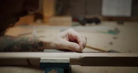 Close up of male hands with tattoos using pincers to cut detail of instrument Stock Footage 137243047