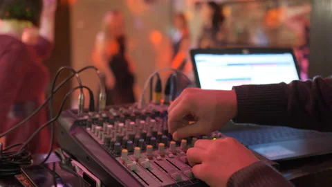Close up of male hands turning knobs on professional DJ mixer console Stock Footage 111285372