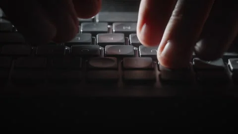 Close-up male hands typing on black keyboard at night, cinematic dolly shot 库存影片 340926581