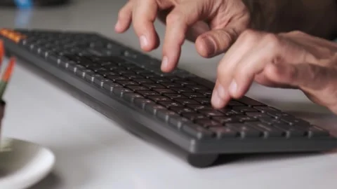 Close-up of male hands typing on computer keyboard in office environment Stock Footage 332329786
