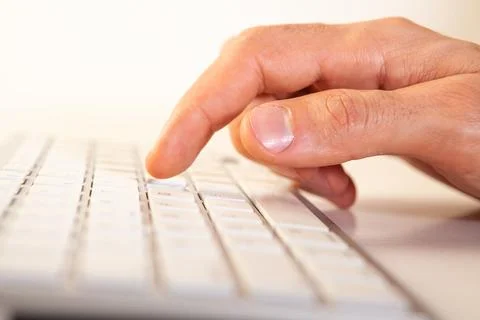 Close up of male hands typing on a computer keyboard on white background Stock Photos