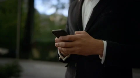 Close-up of male hands typing message on smartphone. He’s texting Messages Video stock 131599498