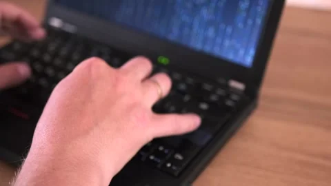 Close-up male hands typing program code on laptop, matrix code on laptop screen Stock Footage 243575954
