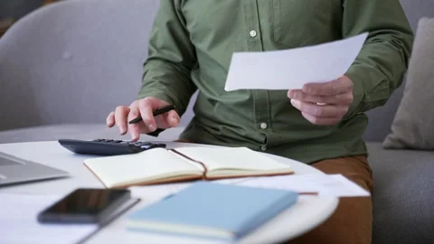 Close-up of male hands using calculator and holding bill while managing Stock Footage 328706945