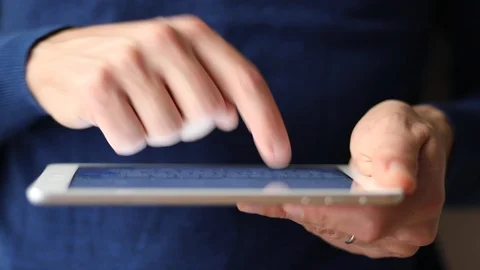 Close-up of male hands using a digital tablet computer, finger touching screen Stock Footage 92251189