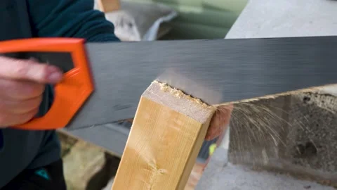 Close up of Male hands using hand saw to cut through hand rail post for garden Stock Footage 142709822