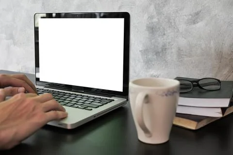 Close up of male hands using laptop with white screen monitor on the desk. Stock Photos