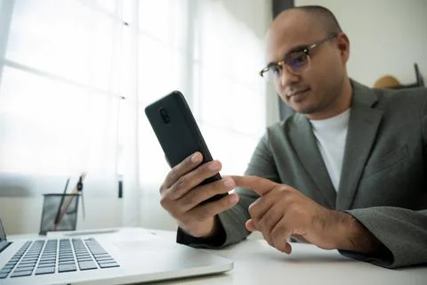 Close up male hands using smartphone and laptop while work from home social d Stock Photos