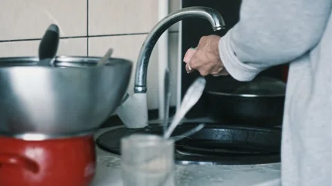 Close-up of male hands using a sponge and soap to wash dirty plates at home Video stock 310373774