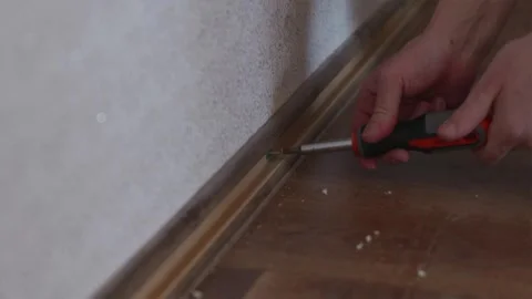 Close up of male hands using tool to pry off baseboard Stock Footage 338003286