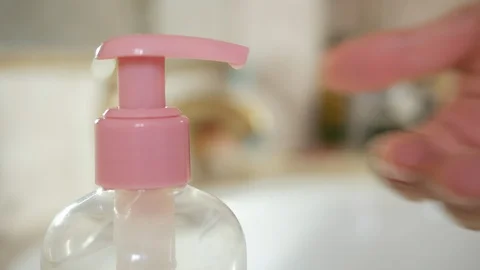 Close up male hands using using a dispenser of cleansing solution, liquid soa Stock-Footage 130076867