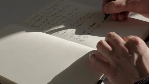 Close-up: Male hands writing text on English with pen on the white page of diary Stock Footage 229896367