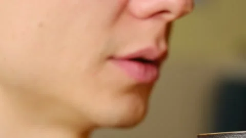 Close-Up of Male Lips Drinking Tea from a Black Ceramic Cup with a Blurred Face Video stock 295780023