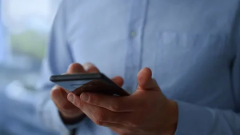 Close-up of male person hands using smartphone or cell phone Tapping scrolling Video stock 336248998