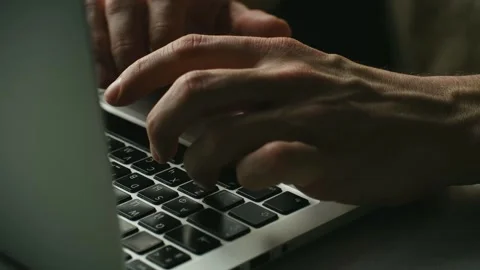 Close up of male programmer hands typing on a laptop keyboard at night Video stock 337828454