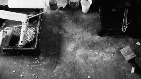 Close-up of a male puts on the table a roller tray and paint,black and white Stock Footage 97353864